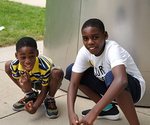 Two young brothers, getting ready to sprint race, squat for a quick photo at a park outside of Chicago.