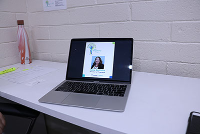 a laptop screen displays a business card