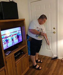 a man sweeps the floor in his living room