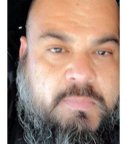 Hispanic male with brown eyes and bald head.