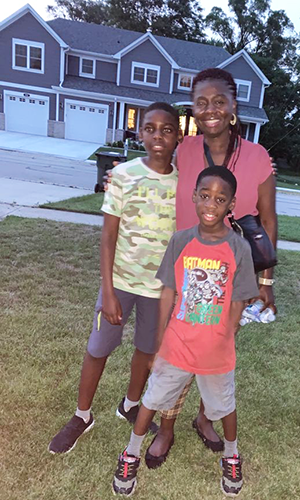 Mom poses with her two young sons outside a home in Chicago.
