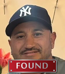 Male with facial hair wearing a baseball cap