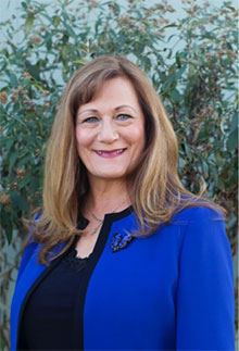 a woman wearing a blue blouse is smiling