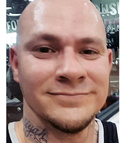 Hispanic male with brown eye and bald head with multiple tattoos.