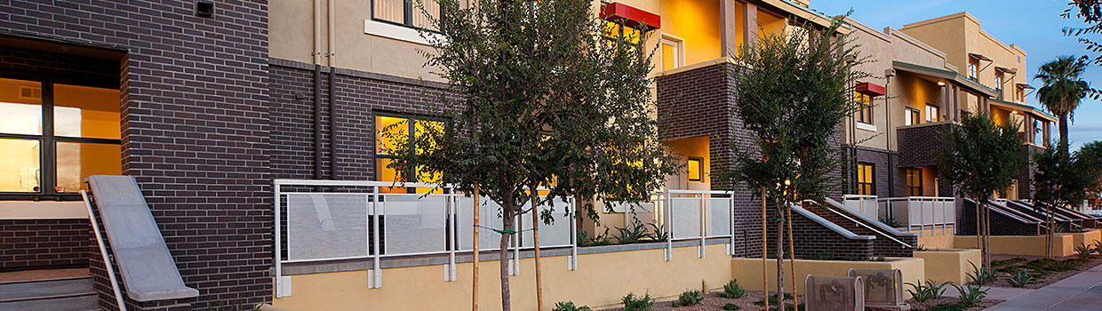 Exterior shot of a low-rise apartment complex at dusk.