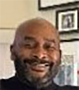 Black male with no hair and brown eyes.
