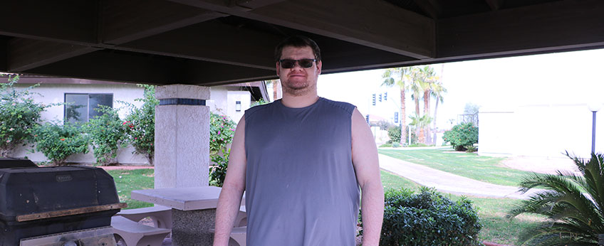 Man stands next to outdoor grill