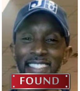 Black male with brown eyes and bald.