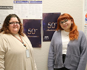 two women standing and smiling