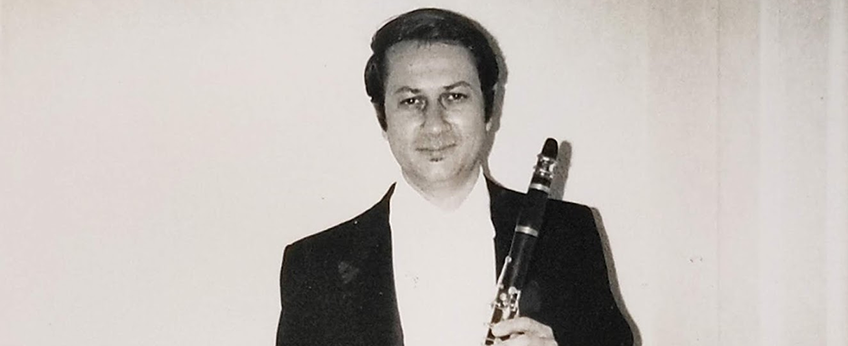 a man wearing a tuxedo is holding a clarinet