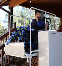 a young man in a wheelchair riding down on a chairlift