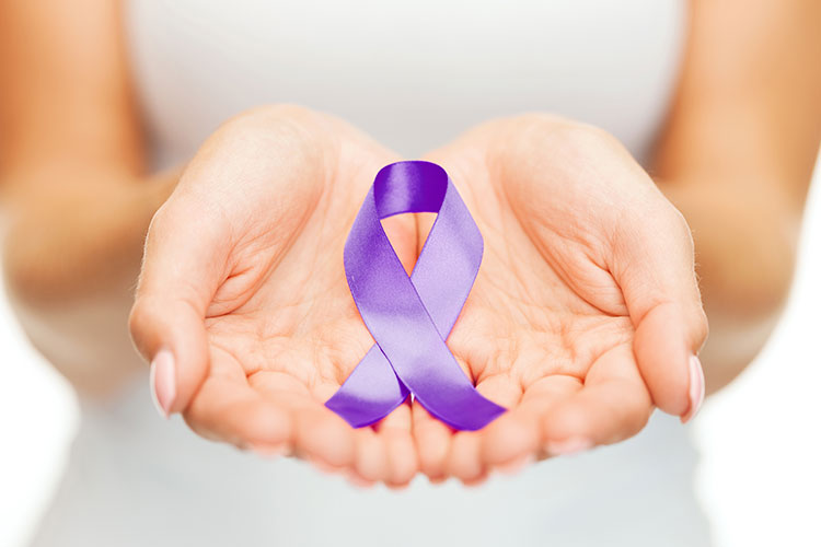 a woman's cupped hands hold a purple ribbon, a symbol of Domestic Violence Awareness