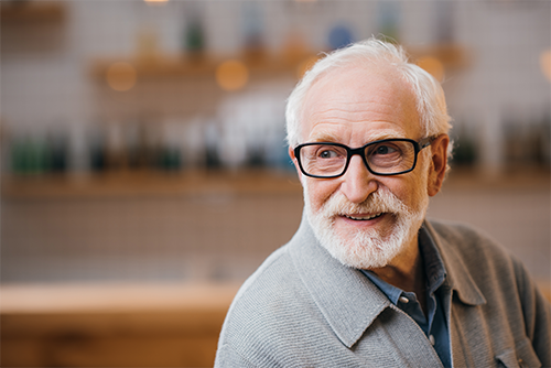 An older man sitting down and smiling