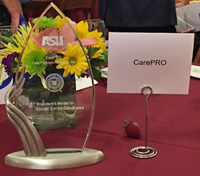 picture of a glass award inscripted with 'ASU' next to a placard with the words 'CarePRO'