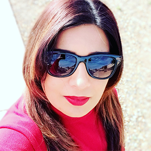 a young woman with long, brown hair is wearing sunglasses and a red blouse