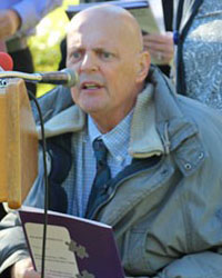 picture of man in a wheelchair speaking into a microphone