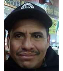 A Hispanic male with brown eyes, black hair and mustache.