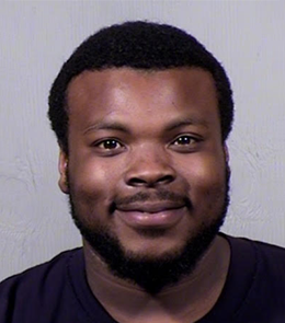 A Black male with brown eyes, black hair, mustache and beard.