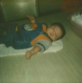 Infant boy lying on his back on the floor
