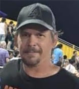 A White male with brown eyes, brown hair, mustache and goatee.