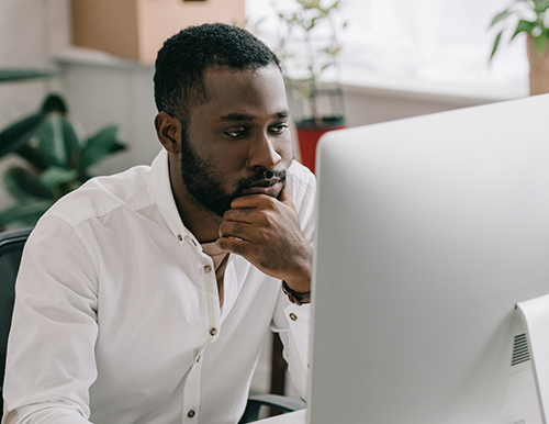 Man working thoughtfully on a computer.