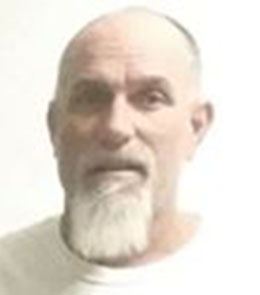 a White male with blue eyes, a bald head, and a white goatee