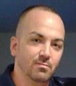 A Hispanic male with green eyes, brown hair, and a mustache 