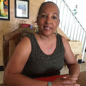 a woman is sitting at a table, smiling