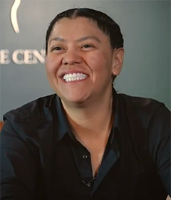 Person wearing a black dress shirt, smiling