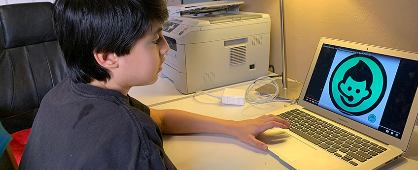 a young boy using a laptop
