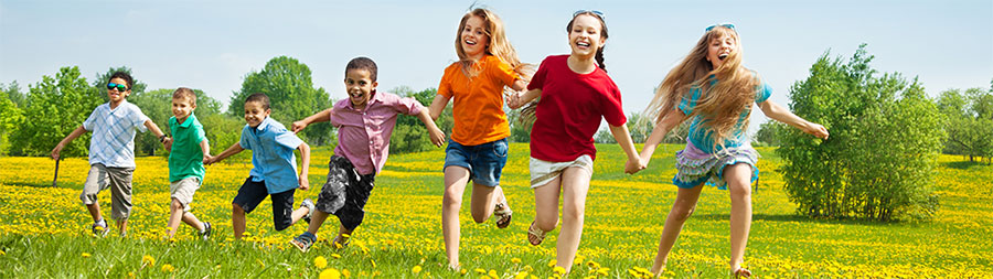 a group of children running in a field of flowers