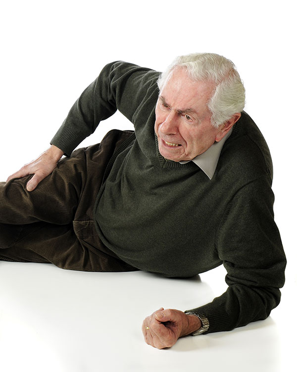 elderly man fallen on the floor holding his hip