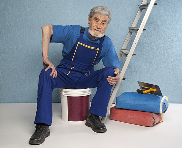 elderly man with a ladder and bucket and other construction equipment