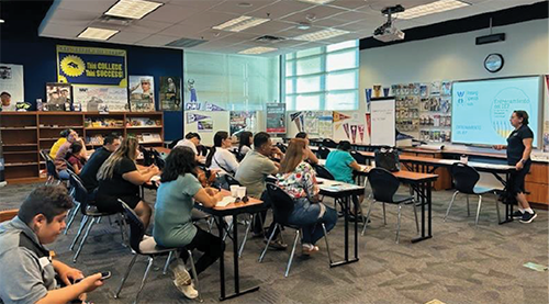 Classroom setting with attendees watching a presentation. Classroom setting with attendees watching a presentation.