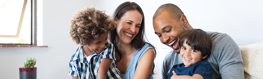 A family of four laughing joyously.