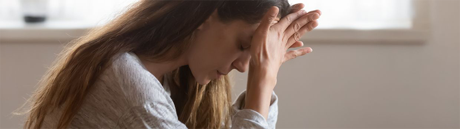 Close-up of a person resting their head in their hands, appearing contemplative.