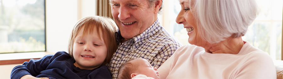 A pair of older adults with a child and baby.
