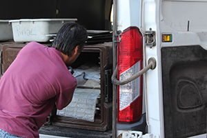 a man is removing packages from the back of a van