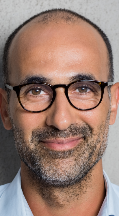 Man with short dark hair and glasses posing for an ID photo