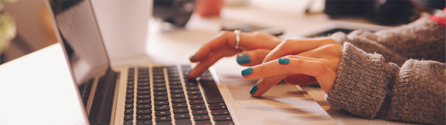 Hands typing on a laptop.