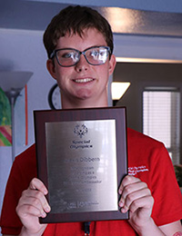 a teenage girl holding up a Special Olympics Unified plaque