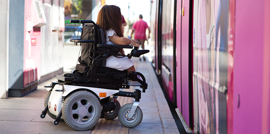 Woman in a wheelchair boarding a train.