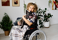 Woman in wheelchair holding her pet dog