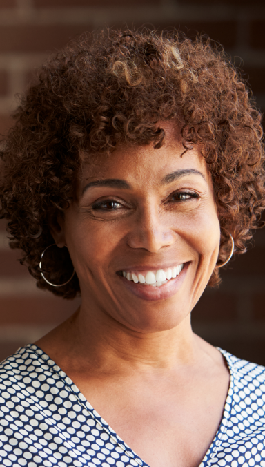 Woman with short, curly dark hair smiling