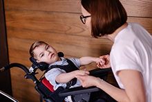 Young boy with cerebral palsy working with a therapist