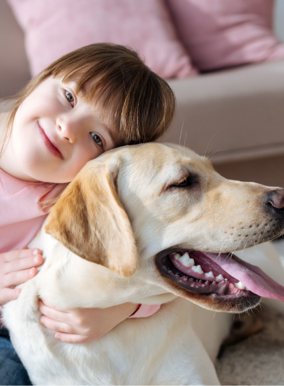 Young girl sitting on the floor hugging her dog.