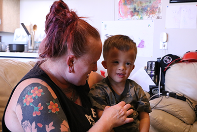 a woman looking at young son who is sitting on her lap