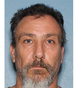 A white man with short, brown hair, blue eyes, and graying mustache and beard