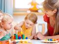 woman sits at a table next to small children