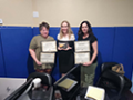 A group of women holding certificates